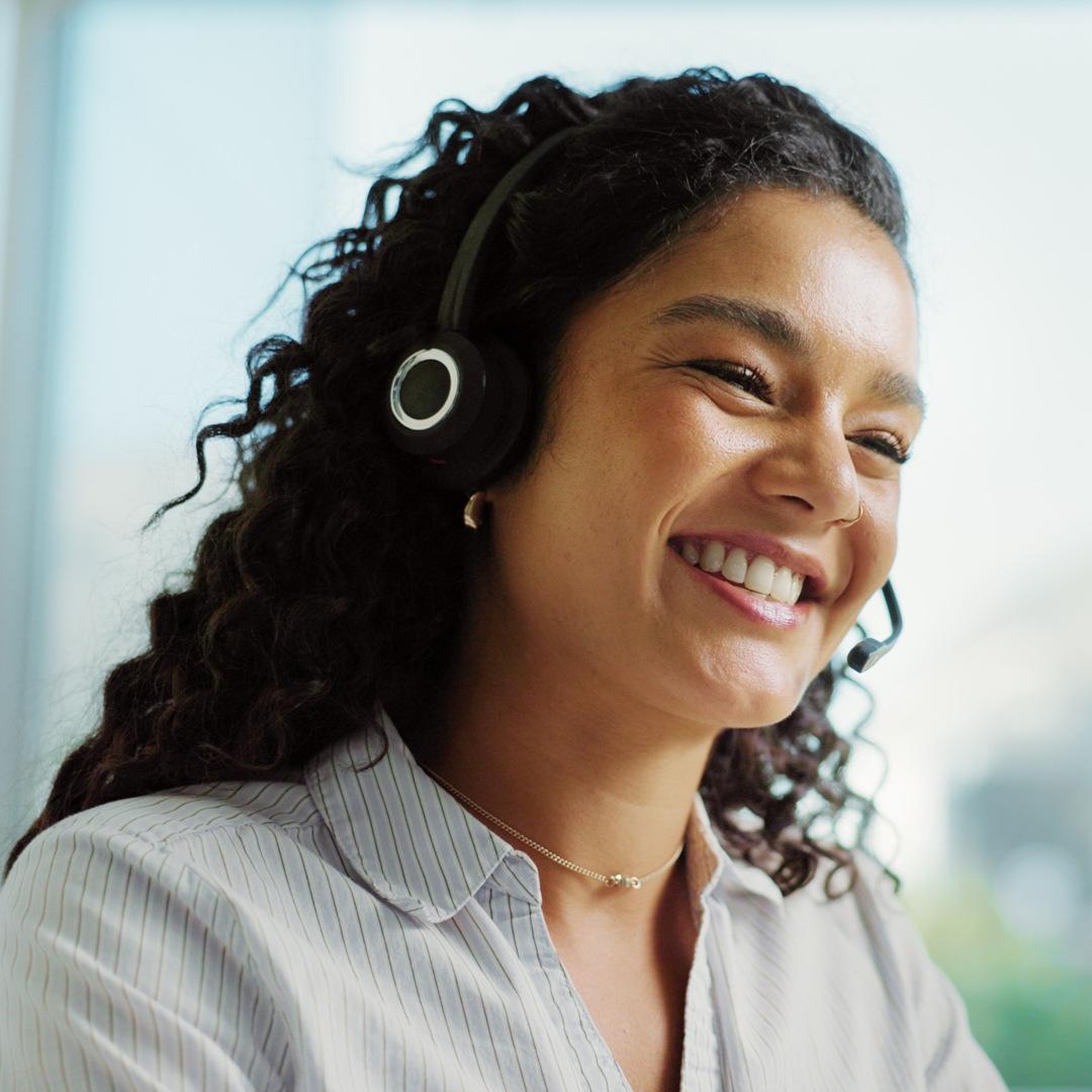 Lächelnde Hotelmitarbeiterin mit Headset unterstützt Gäste professionell und freundlich im Service.