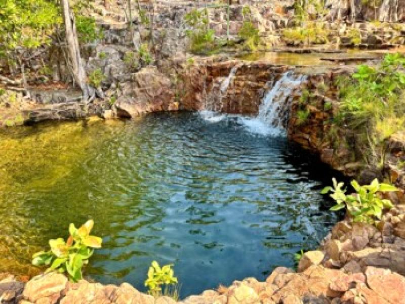 Naturnaher, ruhiger Pool mit klarem Wasser, umgeben von Felsen und &uuml;ppigem Gr&uuml;n f&uuml;r Entspannung.