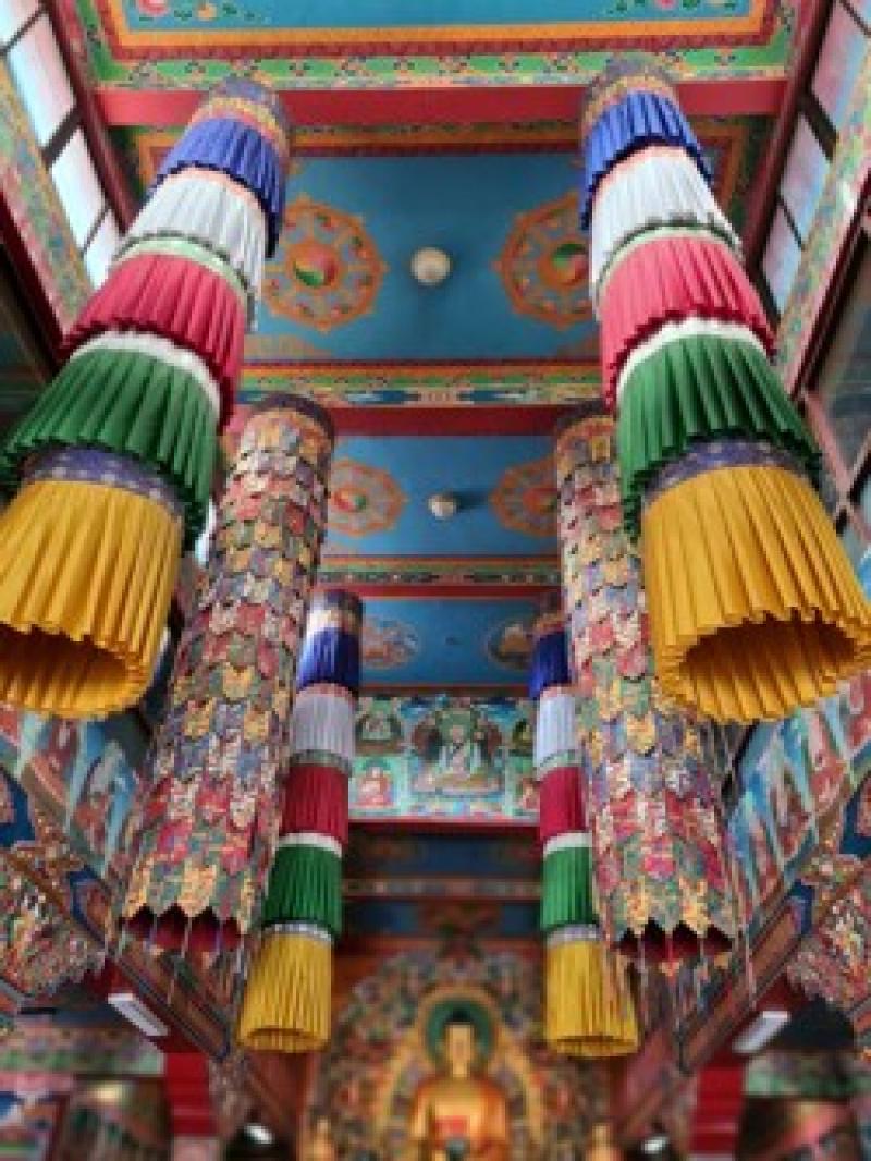 Bunte, kunstvoll verzierte Decken und H&auml;ngedekorationen pr&auml;gen dieses farbenfrohe, spirituelle Interieur.